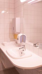 uma casa de banho branca com um lavatório e um espelho em Ullevål Hotel em Oslo