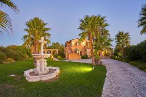 a house with a fountain in front of a yard at Scent Selinunte Garden in Castelvetrano Selinunte