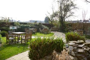 a patio with a table and chairs in a garden at Red Lion Hotel by Greene King Inns in Fareham