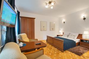 een slaapkamer met een bed en een flatscreen-tv bij Willa Ostoja in Kazimierz Dolny