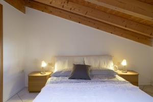 ein Schlafzimmer mit einem weißen Bett und zwei Nachttischen in der Unterkunft B&B Las Vegan in Cles