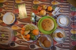 ein Tisch mit Tellern voller Speisen und Obst in der Unterkunft B&B Las Vegan in Cles