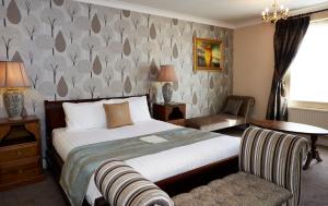 a hotel room with a bed and a chair at Red Lion Hotel by Greene King Inns in Fareham