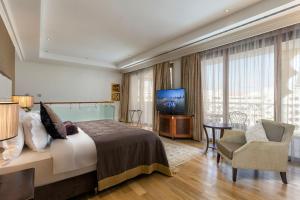 Habitación de hotel con cama y TV en Titanic Mardan Palace en Lara