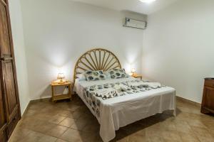 a bedroom with a large bed with blue pillows at Le Villette di Villa Aurora in Lampedusa