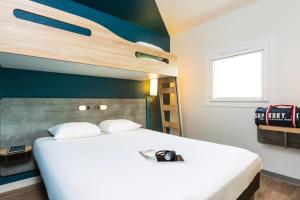 a bedroom with a large white bed and a window at ibis budget Paris Porte d'Italie Est in Le Kremlin-Bicêtre +77 photos