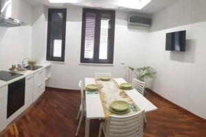 een keuken en eetkamer met een witte tafel en stoelen bij Casual Life Suite in Reggio di Calabria