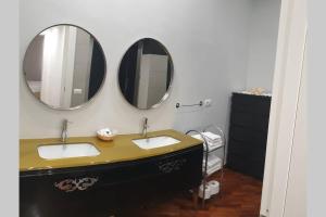 ein Badezimmer mit zwei Waschbecken und zwei Spiegeln in der Unterkunft Casual Life Suite in Reggio di Calabria
