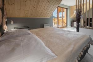 a large bed in a bedroom with a wooden ceiling at Apartament Widok in Jaworki
