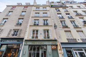 a tall building with a store in front of it at Le Ferdinand - Le Marais Serviced Apartments in Paris