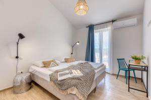 a white bedroom with a bed and a blue chair at Villa Vela Muline - 8 plus 2 guests - heated pool in Ugljan +42 photos