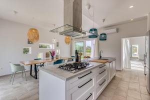 a kitchen with white cabinets and a stove top oven at Villa Vela Muline - 8 plus 2 guests - heated pool in Ugljan