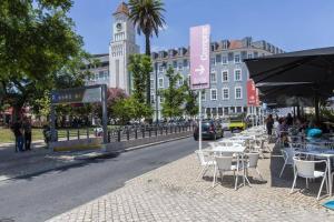 un grupo de mesas y sillas en una calle de la ciudad en Lisbon Prime Studio en Lisboa