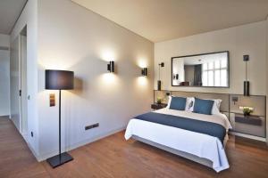 - une chambre avec un grand lit et un miroir dans l'établissement Lisbon Prime Studio, à Lisbonne