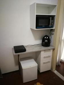 a room with a desk with a microwave and a computer at Appartamento Indipendenza - Tropea centralissimo in Tropea