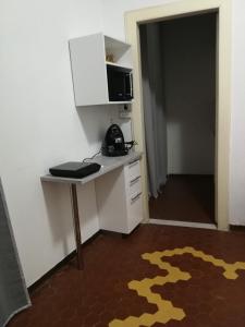 a room with a desk with a microwave and a telephone at Appartamento Indipendenza - Tropea centralissimo in Tropea