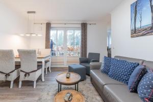 una sala de estar con un sofá y una mesa en Haus Pamir - Ferienwohnungen, en Ostseebad Nienhagen
