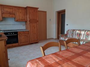a kitchen with wooden cabinets and a table and a couch at Alla vecchia stazione in Tarvisio