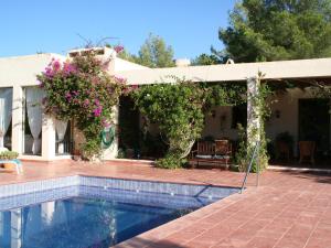 a house with a swimming pool and flowers at Belvilla by OYO Casa Lourdes in Sant Miquel de Balansat