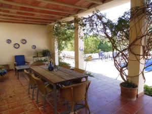 a patio with a wooden table and chairs at Belvilla by OYO Casa Lourdes in Sant Miquel de Balansat