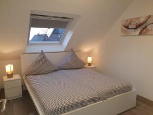 a small bedroom with a bed with two lamps on it at Haus Schneider in Winterberg