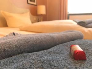a rolled up towel on a bed with two beds at Gästehaus Kaiserhof Lübeck in Lübeck