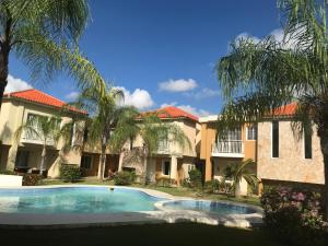 een zwembad voor een gebouw met palmbomen bij Punta Cana Apartment and scooter for free in Punta Cana