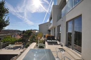 a balcony with a glass table and chairs on a building at Design apartments 3&4 in Mali Lošinj