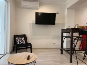 uma sala de estar com uma televisão de ecrã plano na parede em Appartement3 avec terrasse et vue près d'Amoreiras em Lisboa