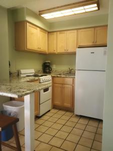 a kitchen with wooden cabinets and a white refrigerator at Ragged Edge Resort & Marina in Islamorada