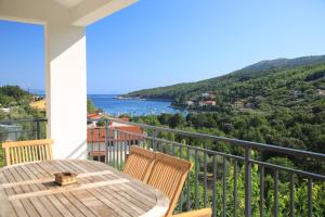 Un balcón con mesa y sillas y vista al agua. en Apartments Ida Sveta Marina, en Drenje