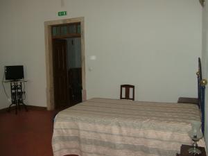 a bedroom with a bed and a television in it at Alentejano Low Cost Hotel in Estremoz