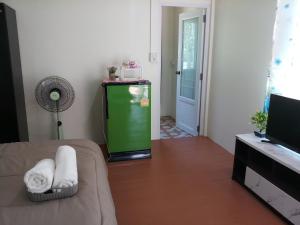 a room with a small green refrigerator in a room at Baan suan khun ta บ้านพักสวนคุณตา in Ko Chang