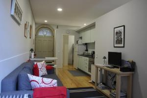 sala de estar con sofá azul y cocina en Practical and Comfortable Apartment with Garden, en Oporto