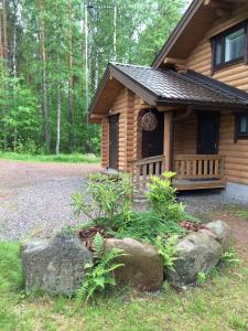 una cabaña de madera con rocas delante en Lappalaisen lomamökit Norpparanta en Puumala