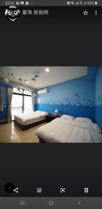 a bedroom with two beds and a blue wall at Passion in Magong