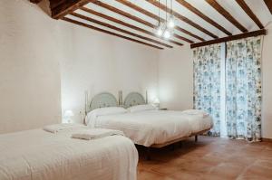 two beds in a room with white walls at Casa Rural Villa Margarita in Dosbarrios +25 photos