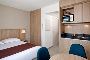Habitación de hotel con cama y lavabo en Residhome Lyon Gerland, en Lyon