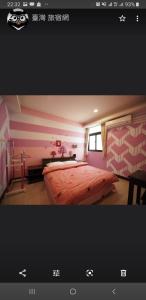 a bedroom with a large bed with pink and white stripes at Passion in Magong