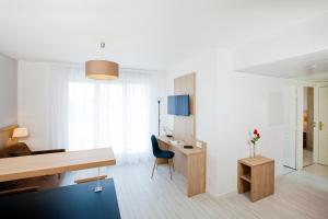 Cette chambre blanche dispose d'un bureau et d'une chaise. dans l'établissement Residhome Lyon Gerland, à Lyon