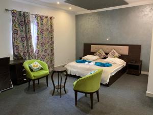1 dormitorio con 1 cama, mesa y sillas en Capital Hôtel en Brazzaville