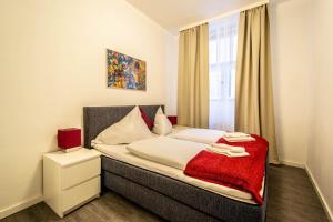 プラハにあるLabyrinth apartments by Ruterraのベッドルーム1室(赤い毛布付きのベッド1台付)