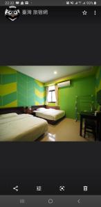 a bedroom with two beds and a desk and a window at Passion in Magong
