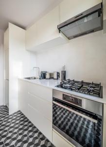 een keuken met witte kasten en een fornuis met oven bij Mini loft 1 bedroom 2 steps from Av Louise in Brussel