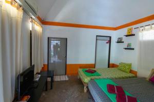 a living room with a bed and a tv and a couch at Ban_na in Ko Chang