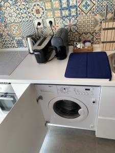 a counter with a washing machine in a kitchen at Studio ensoleillé avec terrasse proche d'Amoreiras in Lisbon