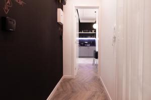 a hallway with a black wall and a white room at Tesla Design Apartments Zagreb in Zagreb