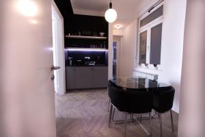 a dining room with a glass table and black chairs at Tesla Design Apartments Zagreb in Zagreb
