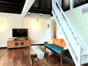 - un salon avec un canapé et une télévision dans l'établissement Bedugul Lake View Residence Unit B-6, à Bedugul