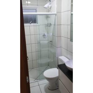 La salle de bains est pourvue de toilettes et d'une douche en verre. dans l'établissement Apartamento Novinho Próximo as Praias, Centro e Restaurantes - Excelente localização, à Ubatuba